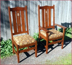 Arm chair and side chair from a lighter stained set of chairs upholstered in fabric.